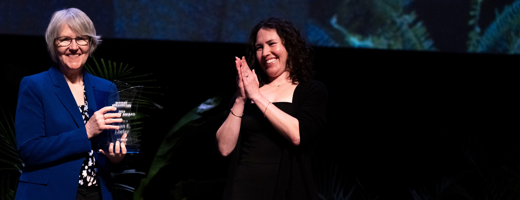 Sue Ebeler accepting the award from Kelly Brown on stage.