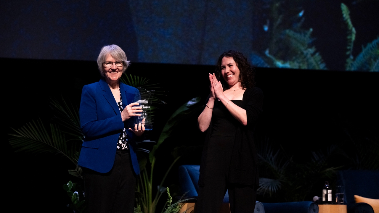 Sue Ebeler accepting the award from Kelly Brown on stage.